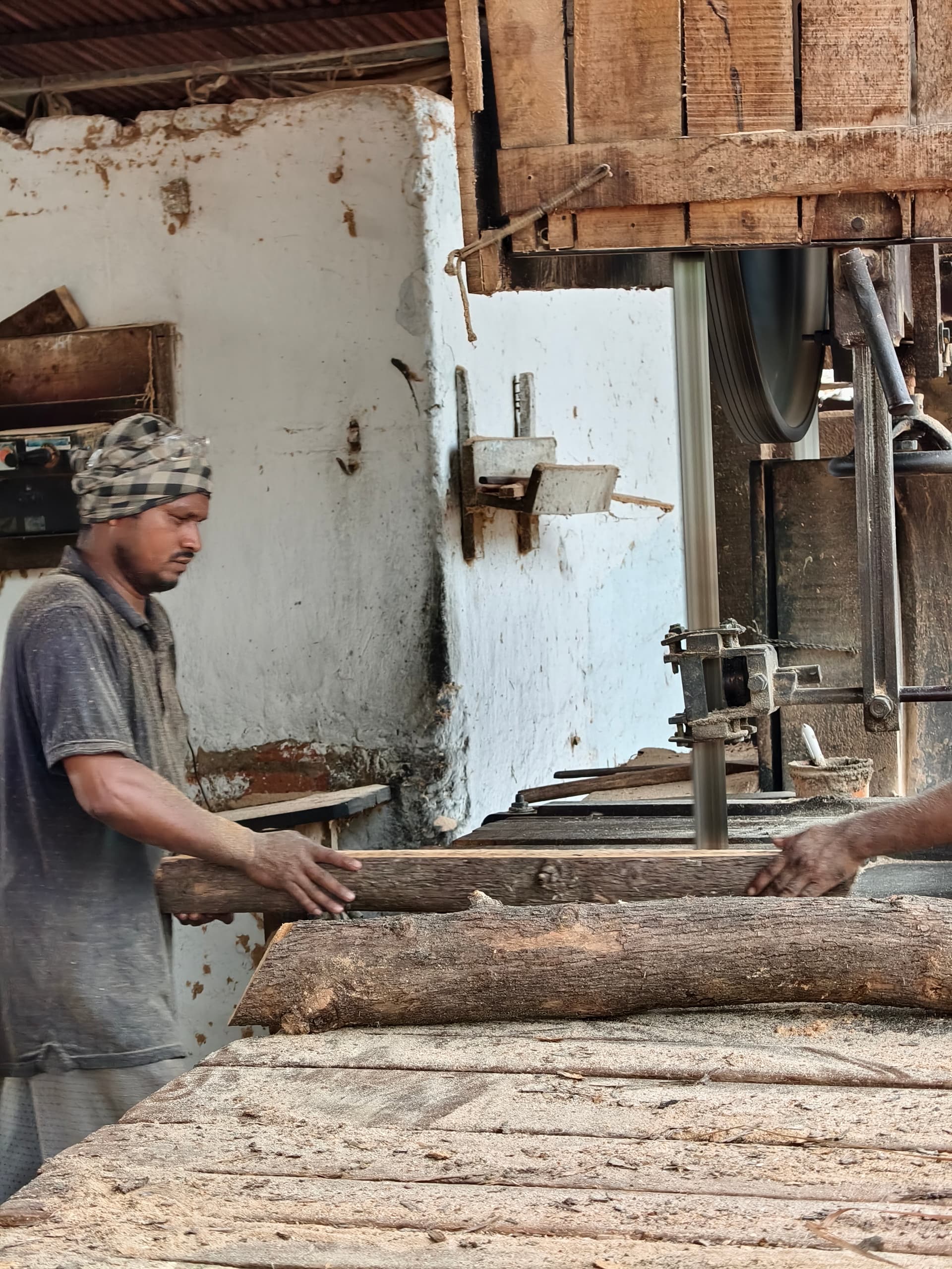 Timber worker handling wood planks at Sri Vijaya Sankara Saw Mill, Parvathipuram